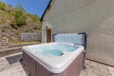 a hot tub sitting outside of a building at Maesgwyn in Felindre