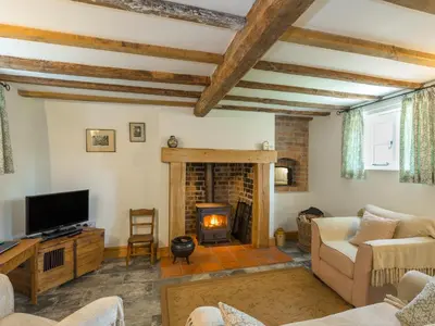a living room with a fireplace and a tv at Stone House in Ludlow