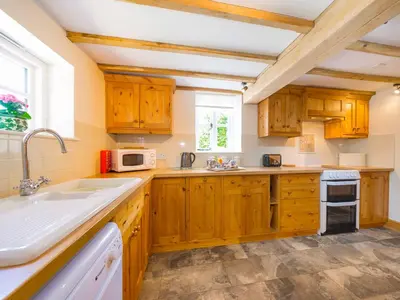 a kitchen with wooden cabinets and a sink at Stone House in Ludlow