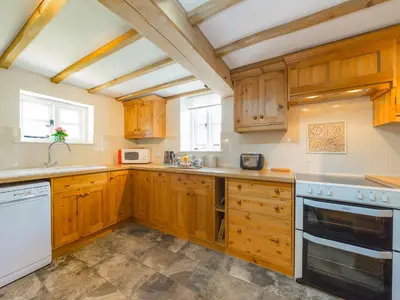 a kitchen with wooden cabinets and white appliances at Stone House in Ludlow