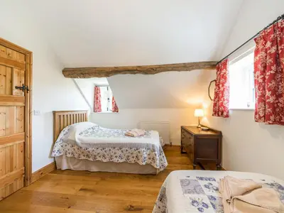a bedroom with two beds and a dresser and two windows at Stone House in Ludlow