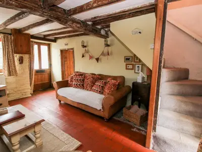 a living room with a couch and a staircase at Castle Cottage in Clun
