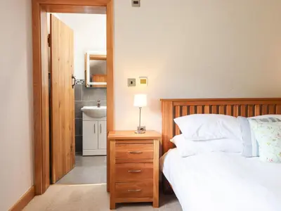 a bedroom with a bed and a lamp on a night stand at Ty Gwyn in Llangwm
