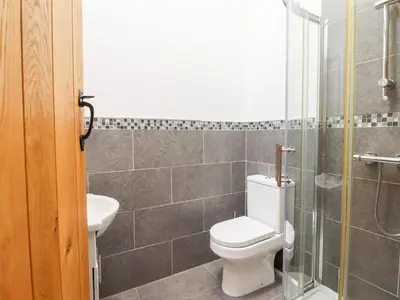 a bathroom with a toilet and a glass shower at Ty Gwyn in Llangwm