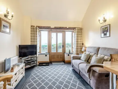 a living room with a couch and a tv at The Granary in Llanfair Caereinion