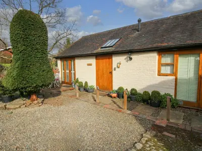 a house with a large tree next to it at The Milking Parlour in Leominster