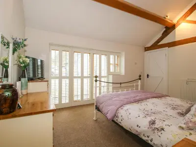 a bedroom with a bed and a desk and window at The Milking Parlour in Leominster