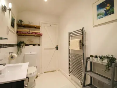 a bathroom with a white toilet and a sink at The Milking Parlour in Leominster
