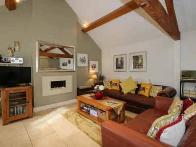 a living room with a couch and a tv at The Milking Parlour in Leominster