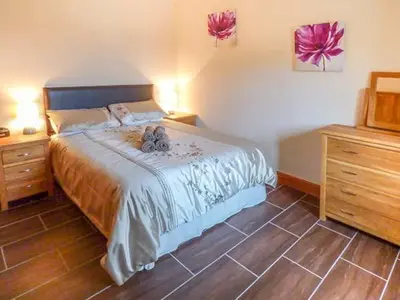 a bedroom with a bed with two teddy bears on it at Y Bwthyn in Ystrad Meurig