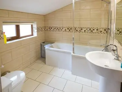a bathroom with a tub and a toilet and a sink at Y Bwthyn in Ystrad Meurig
