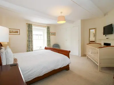 a bedroom with a bed and a crib at The Laurels in Bishops Castle