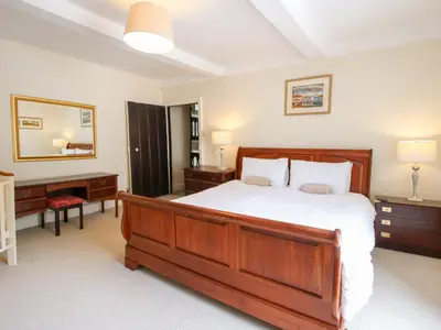 a bedroom with a large wooden bed and a desk at The Laurels in Bishops Castle