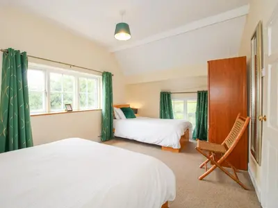 a bedroom with two beds and a chair at The Laurels in Bishops Castle