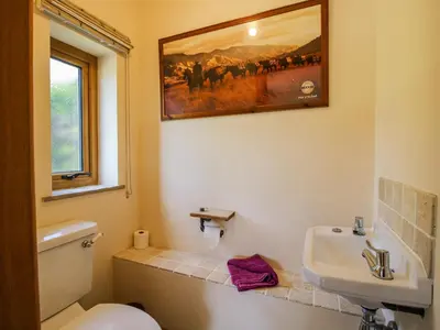 a bathroom with a white toilet and a sink at The Hayloft in Knighton