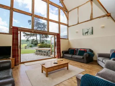 a living room with couches and a table at The Hayloft in Knighton