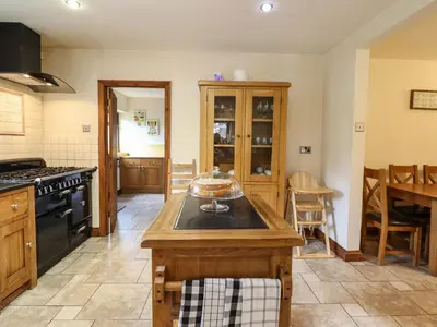 a kitchen with an island in the middle at Ty Newydd in Pont Dolanog