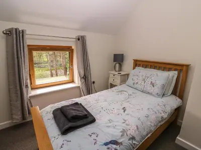 a bedroom with a bed and a window at The Farmhouse in Capel Bangor