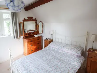 a bedroom with a bed and a dresser and a mirror at The Smithy in Leominster