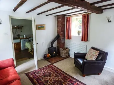 a living room with a leather chair and a fireplace at The Smithy in Leominster