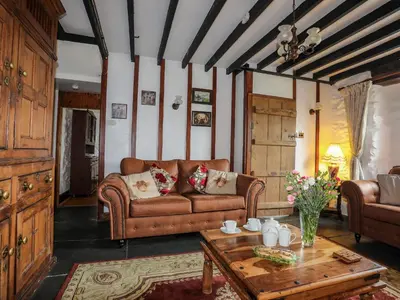 a living room with a couch and a table at Hendy Cottage in Llanbedr
