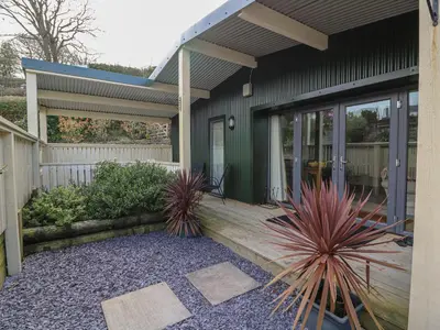 a porch of a house with two plants at Y Felin - Moana in Borth