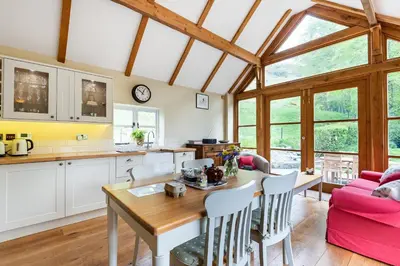 a kitchen and living room with a wooden table and chairs at Pen Y Bont in Llangollen