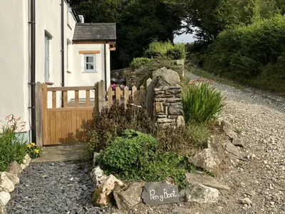 a fence in front of a house with a garden at Pen Y Bont in Llangollen