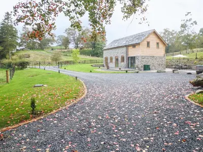 a gravel driveway leading to a stone building at Tynddol Barn in Llanbadarn-fynydd