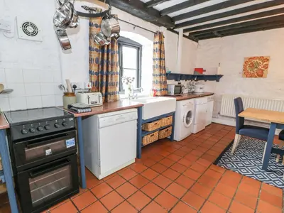 a kitchen with a sink and a stove at The Corn Store in Corwen