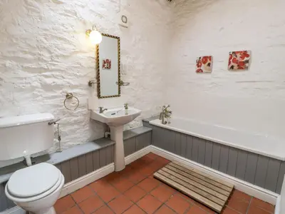 a bathroom with a toilet and a sink and a tub at The Dairy in Corwen