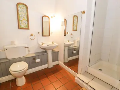 a bathroom with two sinks and a toilet and a shower at The Dairy in Corwen