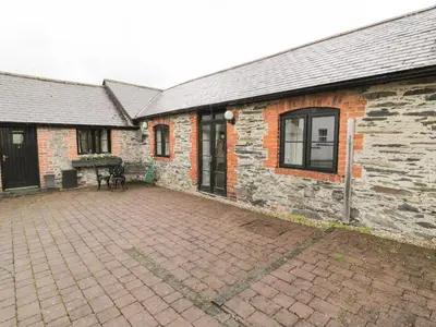 a brick building with a patio in front of it at The Dairy in Corwen