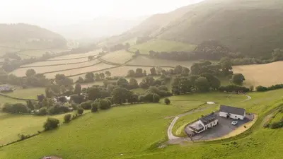 an aerial view of a farm in a green field at Tyn Llwyn in Llangollen