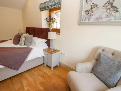a bedroom with a bed and a chair at The Old Farmhouse in Craven Arms