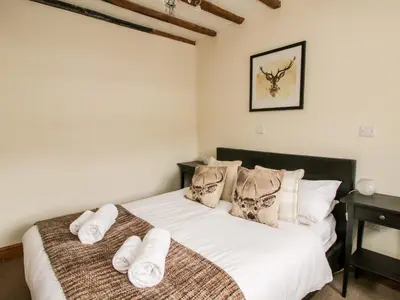 a bedroom with a bed with white sheets and pillows at The Old Farmhouse in Craven Arms