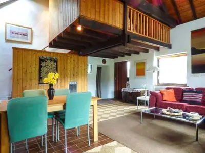 a living room with a table and blue chairs at Ty Uchaf in Llangwm