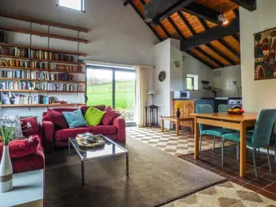a living room with a red couch and a table at Ty Uchaf in Llangwm