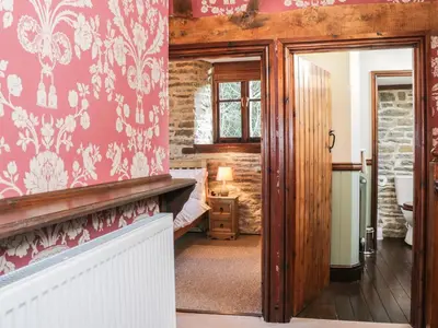 a room with pink walls and a bedroom with a bed at The Granary in Bucknell