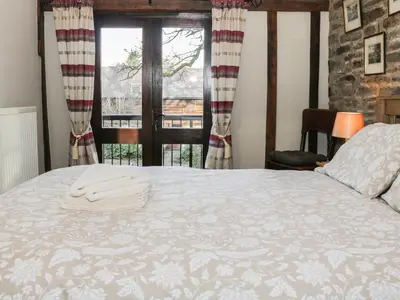 a bedroom with a large bed with a window at The Granary in Bucknell