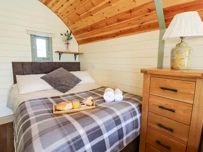 a bedroom with a bed with a tray of bread at Meadow View in Saint Harmon