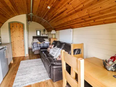a living room with a leather couch and a bed at Meadow View in Saint Harmon