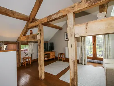 a living room with wooden beams at The Hay Loft in Craven Arms