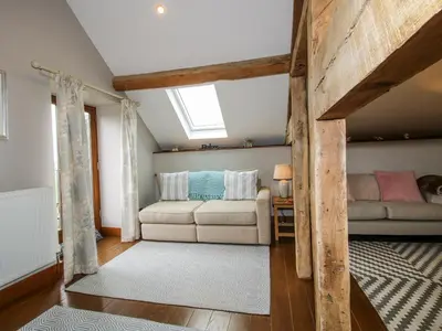 a living room with a couch and a window at The Hay Loft in Craven Arms