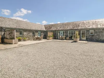 an empty driveway in front of a stone building at Bwthyn Bach in Llanddwywe