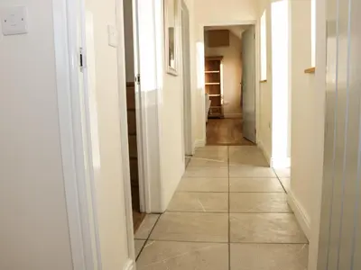 a hallway with white walls and a tile floor at Swallow Barn in Walford