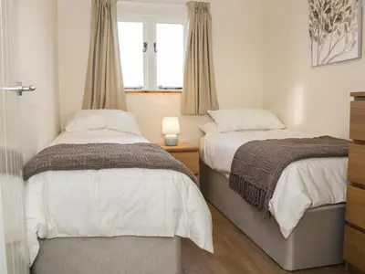 a bedroom with two beds and a window at Swallow Barn in Walford