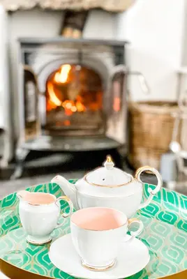 a tea set on a table with two cups and a stove at Pen Y Bont Cottage Llanuwchllyn Bala in Llanuwchllyn