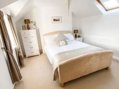a white bedroom with a bed and a dresser at Pen Y Bont Cottage Llanuwchllyn Bala in Llanuwchllyn