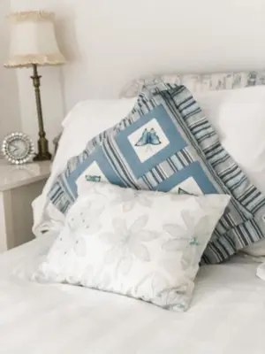a bed with blue and white pillows on it at Pen Y Bont Cottage Llanuwchllyn Bala in Llanuwchllyn